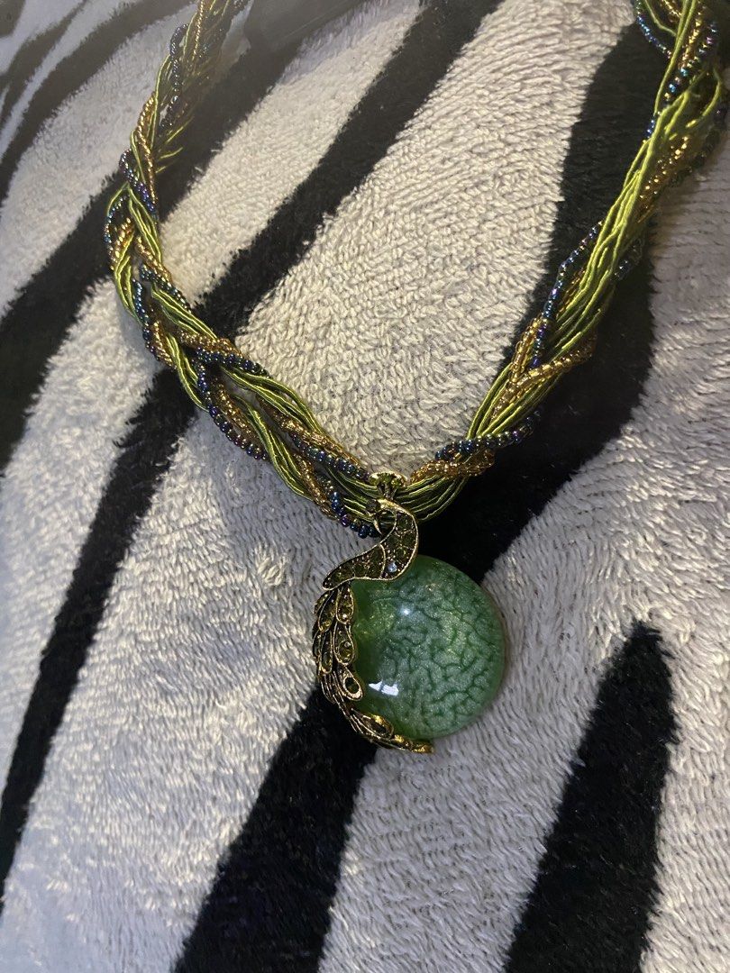 Statement/Chunky collar necklace (Category: Luxury Accessories) located in Manila. Submitted by ddxyatchang (Listing ID 1460534087, Image 3). Description: Statement / Chunky Collar Necklace Design Motif: Peacock pendant Centerpiece Stone: Light green round cabochon stone with a crackle/dragon vein texture (typically crackle agate, glass, or resin). Pendant Details: Antique gold-tone/bronze metal styled as a stylized peacock perched along the side