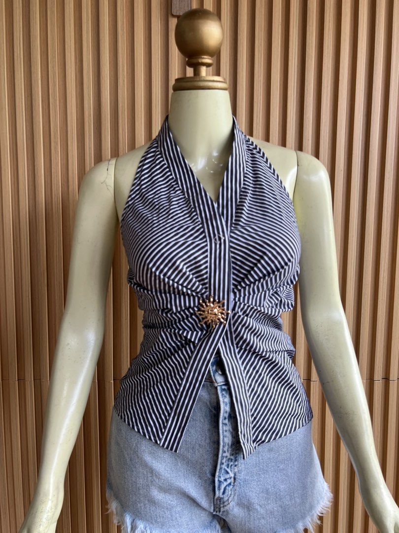 Striped Halter Top with Sun Brooch (Category: Sleeveless) located in Lipa City. Submitted by thyra06 (Listing ID 1460641150, Image 3). Description: - Black and white striped halter top - Features a tie-front detail - Adorned with a gold sun brooch - Sleeveless design - Versatile: pairs well with shorts or jeans - Ideal for casual outings or beach vacations.