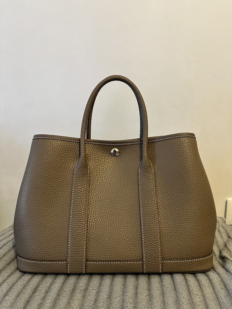 Tote Bag - Pebbled Leather, Taupe (Category: Tote Bags) located in Manila. Submitted by seej0991 (Listing ID 1460593653, Image 1). Description: - Classic tote bag style - Genuine Cowhide Leather - Central snap closure - Interior zippered pocket - Herringbone patterned lining - Ideal everyday bag - Garden Party - Inspired Tote Bag - Price Negotiable - Newly Purchased (2 Week old) - Complete with Dust Bag.