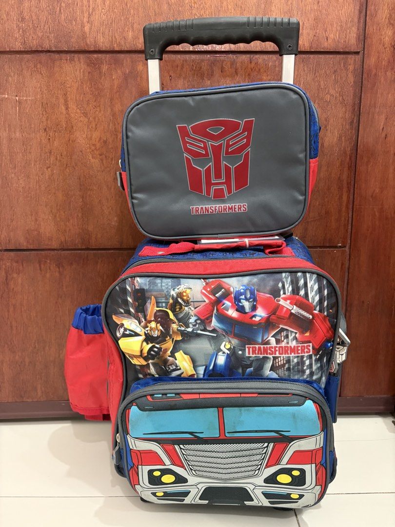 Transformers Rolling Backpack with Lunch Bag (Category: Backpacks) located in Manila. Submitted by kdp202 (Listing ID 1460639579, Image 1). Description: - Features cool Optimus Prime and Bumblebee graphics. - Includes a detachable lunch bag with the Autobot logo. - Stylish blue and red design with a Transformers pattern. - Ideal for school or travel. - Easy to pull with wheels and an extendable handle..