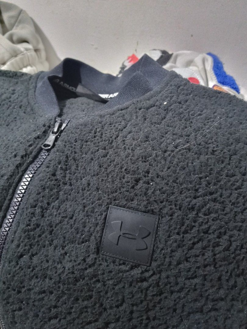 Under Armour Black Fleece Bomber Jacket (Category: Coats, Jackets and Outerwear) located in Lingayen. Submitted by rahzzelula73279 (Listing ID 1460668285, Image 2). Description: - Black Under Armour Fleece Bomber Jacket - Full zip closure - Ribbed collar and cuffs - Two front pockets - Made in the Philippines - Body: 100% Polyester - Overlays: 87% Polyester, 13% Elastane - Perfect for layering.