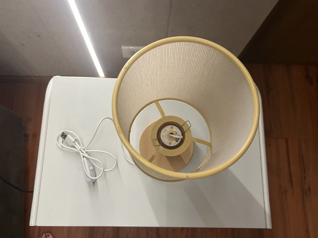 USB Table Lamp with Fabric Shade (Category: Lighting) located in Manila. Submitted by mxinii (Listing ID 1460620579, Image 2). Description: - Simple and stylish bedside lamp - Features a soft fabric shade - Convenient USB power cord with inline switch - Light tan colored base - Includes energy-efficient LED bulb - Ideal size for small desks or nightstands - Easy to turn on and off.