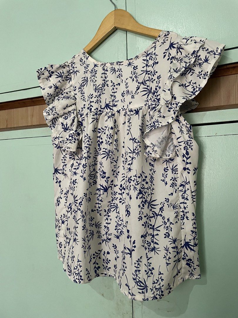 White and Blue Floral Print Flutter Sleeve Top (Category: Blouses) located in Mabalacat. Submitted by heybhaneyy (Listing ID 1460536320, Image 1). Description: - Cute white top - Blue floral print - Flutter sleeves for a flowy look - Light and breathable fabric - Easy to pair with jeans or skirts - Great for everyday wear or a day out.