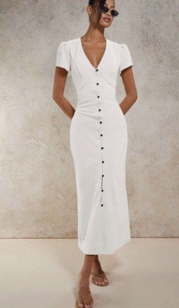 White Button-Front Midi Dress with Corset Back (Category: Dresses) located in Makati City. Submitted by eliza_gwen (Listing ID 1460550474, Image 1). Description: - White midi dress - Short puff sleeves - V-neckline - Button-down front - Corset lace-up detail at the back for adjustable fit - Textured fabric - Versatile for dressing up or down.