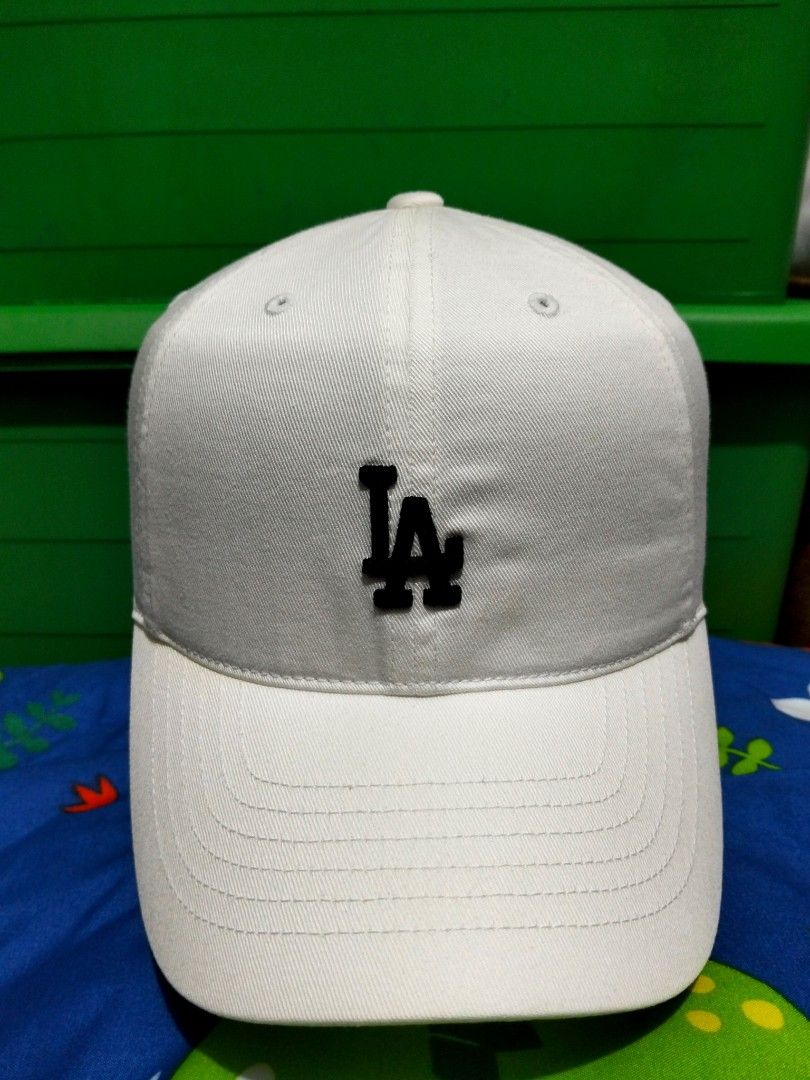 White MLB LA Dodgers Baseball Cap (Category: Caps & Hats) located in San Mateo. Submitted by JmThriftCap_Ph (Listing ID 1460710114, Image 1). Description: MY BIRTHDAY MONTH SALE ☺️ - Official MLB LA Dodgers white cap - Adjustable strap for a comfortable fit - Ideal for sunny weather and casual style - Clean and simple design.