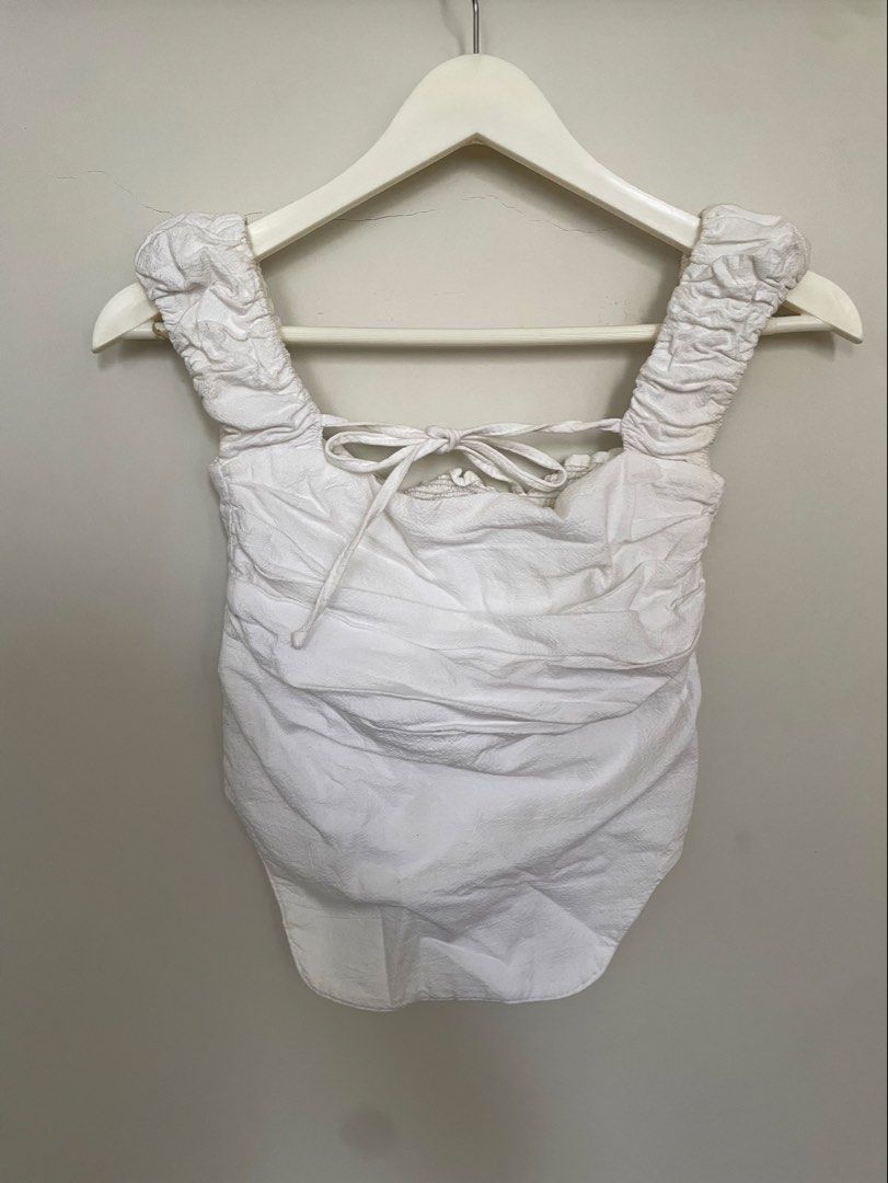 White Ruched Corset Top with Tie (Category: Sleeveless) located in Makati City. Submitted by alyslittlelamb (Listing ID 1460672311, Image 2). Description: - Trendy white ruched corset top - Adjustable tie back straps - Smocked back panel for a snug fit - Ruched sleeves - Versatile for night outs or casual wear.