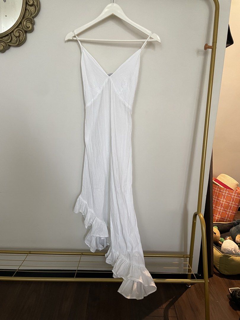 White Spaghetti Strap Ruffle Hem Maxi Dress (Category: Dresses) located in Makati City. Submitted by alyslittlelamb (Listing ID 1460663664, Image 1). Description: - Flowy white maxi dress - Spaghetti straps - Smocked back for a comfortable, adjustable fit - Asymmetrical hemline with delicate ruffle details - Lightweight fabric, ideal for warm weather - Perfect for beach days, summer evenings, or casual outings.