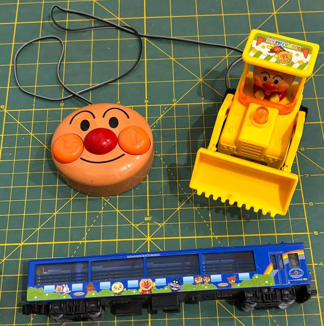 Working Anpanman Bulldozer Remote Control Toy (Category: Remote Control Toys) located in Cavite. Submitted by l1ttlelulu (Listing ID 1460649396, Image 1). Description: - Set of Anpanman toys - Blue train with character designs - Yellow bulldozer with a driver - Round Anpanman remote control with buttons - Ideal for fans of the Anpanman series.