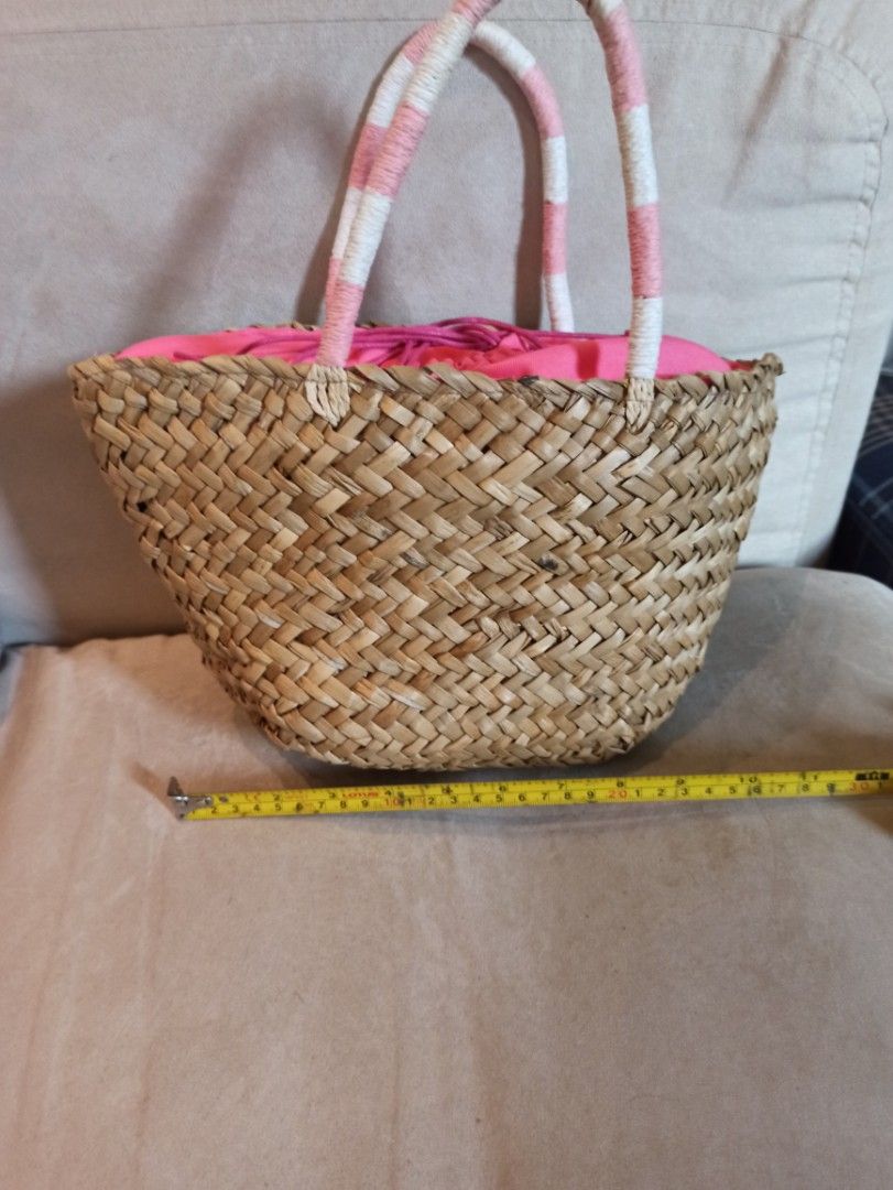 Woven Straw Bag with Pink Lining and Handles (Category: Beach Bags) located in Caloocan City. Submitted by rtarellano (Listing ID 1460549293, Image 2). Description: - Adorable woven straw bag - Features a vibrant pink lining - Secure drawstring closure - Stylish pink and white striped handles - Ideal for beach days or everyday casual wear - Dimensions: Approximately 7 inches tall, 6 inches wide at the base.