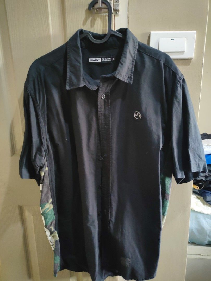 XLARGE Short Sleeve Button Up Shirt Camo Panel (Category: Tshirts & Polo Shirts ) located in Manila. Submitted by robertjust66965 (Listing ID 1460514959, Image 1). Description: - XLARGE short sleeve button-up shirt - Color: Black with camouflage side panels - Features iconic XLARGE gorilla logo on chest - Perfect for casual outfits.