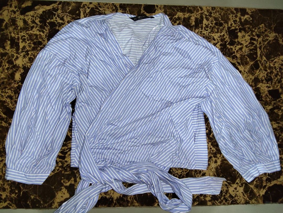 Zara Blue and White Striped Wrap Blouse (Category: Blouses) located in Manila. Submitted by chocobutternut_ (Listing ID 1460590529, Image 1). Description: - Zara blue and white striped wrap blouse - Long balloon sleeves with elastic cuffs - Tie waist closure - Lightweight fabric - Versatile for dressing up or down - can fit up to semi large.