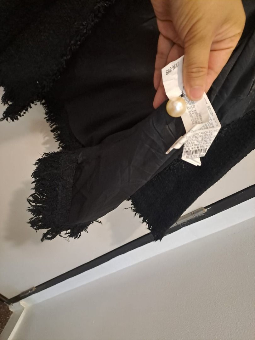 Zara tweed black (Category: Coats, Jackets and Outerwear) located in Mandaluyong City. Submitted by epicowl-c93c (Listing ID 1460536925, Image 3). Description: This item is an authentic Zara Woman black military tweed jacket featuring prominent faux-pearl buttons and frayed trim details. Material & Texture: Crafted from a mid-weight bouclé tweed with delicate frayed raw edges along the collarless opening and cuffs. Hardware: Outfitted with struct