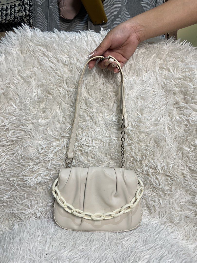 Zara White Ruched Chain Shoulder Bag (Category: Shoulder Bags) located in Manila. Submitted by yanya97 (Listing ID 1460536556, Image 1). Description: - Chic white ruched shoulder bag from Zara. - Features a trendy chunky white chain on the front. - Includes a detachable thin silver chain strap for versatility. - Secure magnetic snap closure. - Multiple compartments inside for organization. - Ideal accessory for your next night out..