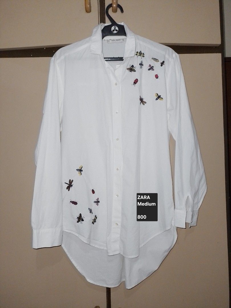 Zara White Shirt with Embroidered Bugs - Medium (Category: Shirts) located in Andop. Submitted by myramaningo.1220 (Listing ID 1460570481, Image 1). Description: White button-up shirt from Zara. Features cute embroidered bugs all over. Long sleeves. Size Medium. Great for a casual look..